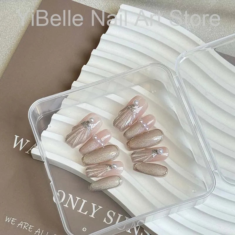 Unhas postiças artesanais em formato de conchas do mar, estilo bailarina, profissionais, reutilizáveis e com brilho perolado.