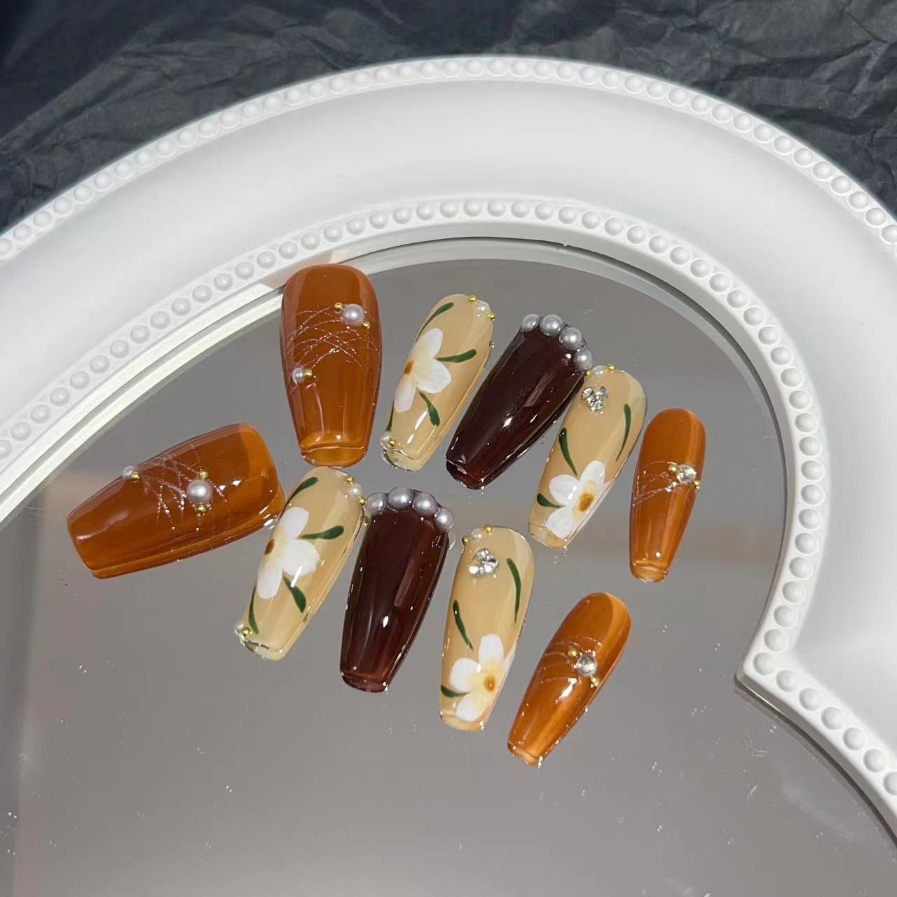 Manicure para usar, manicure artesanal pura, unha postiça finalizada, outono/inverno, cor caramelo, camélia pintada à mão, luz suave.