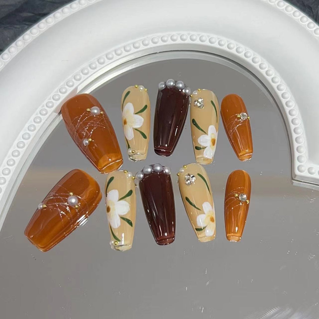 Manicure para usar, manicure artesanal pura, unha postiça finalizada, outono/inverno, cor caramelo, camélia pintada à mão, luz suave.