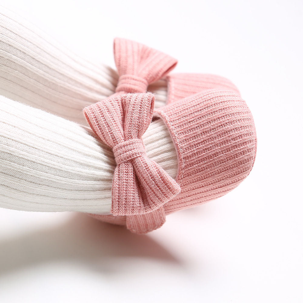 Sapatinhos de bebê com sola macia e estampa floral fofa, ideais para crianças pequenas e feitos de tecido respirável.