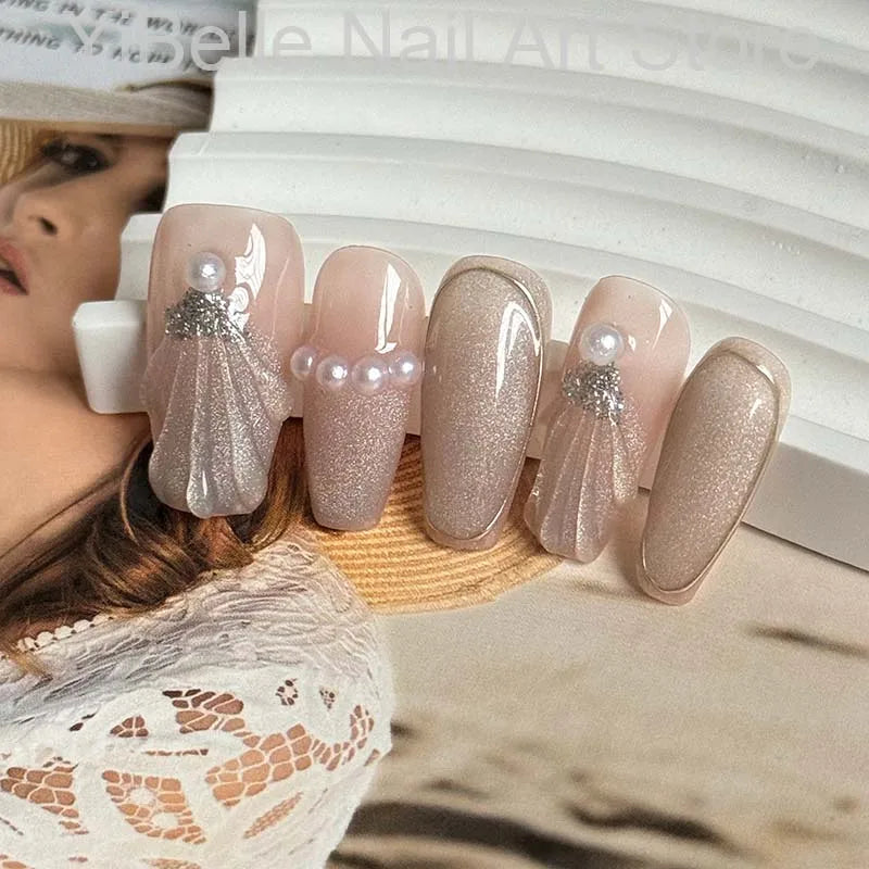 Unhas postiças artesanais em formato de conchas do mar, estilo bailarina, profissionais, reutilizáveis e com brilho perolado.