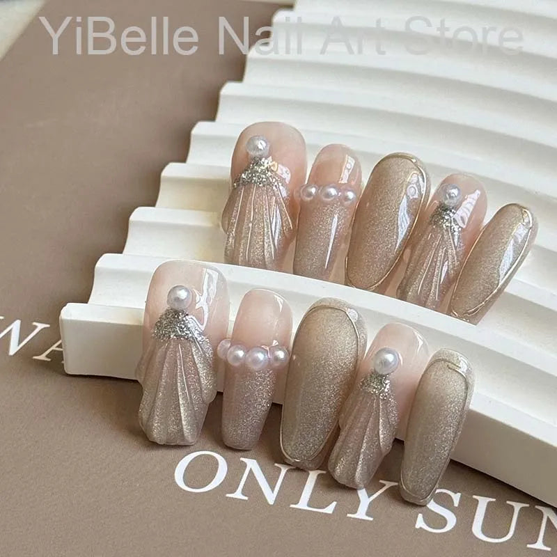 Unhas postiças artesanais em formato de conchas do mar, estilo bailarina, profissionais, reutilizáveis e com brilho perolado.