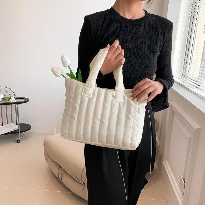 Bolsa de mão grande, simples e exclusiva, em algodão, com bordados modernos.