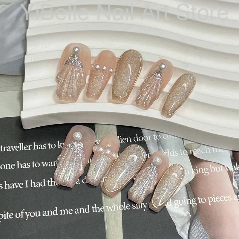 Unhas postiças artesanais em formato de conchas do mar, estilo bailarina, profissionais, reutilizáveis e com brilho perolado.