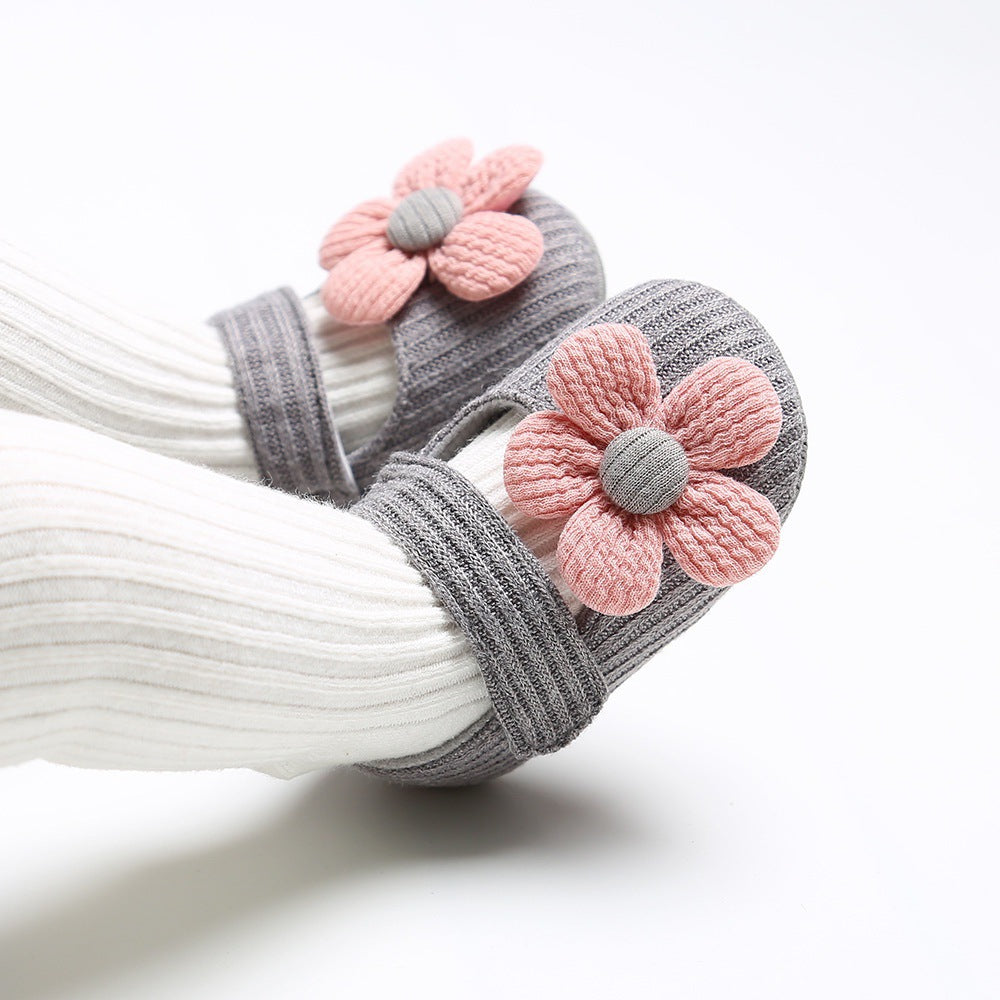 Sapatinhos de bebê com sola macia e estampa floral fofa, ideais para crianças pequenas e feitos de tecido respirável.