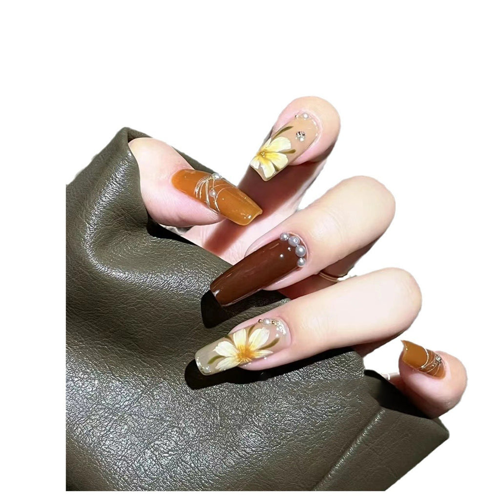 Manicure para usar, manicure artesanal pura, unha postiça finalizada, outono/inverno, cor caramelo, camélia pintada à mão, luz suave.