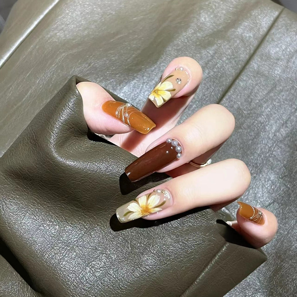 Manicure para usar, manicure artesanal pura, unha postiça finalizada, outono/inverno, cor caramelo, camélia pintada à mão, luz suave.